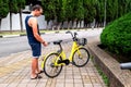 BIKE YELLOW and mobile phone. man using e vehicle rent service with smartphone in urban city street and park. Young man rent an