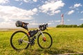 Bikepacking at the north sea, view on the lighthouse of campen near emden with a packed gravel bike in front, north sea, germany