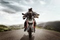 Biker on mountain highway, riding around a curve with a motion blur toned with a retro vintage instagram filter app or Royalty Free Stock Photo