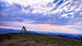 Biker on background of mountains and sky with clouds, national n