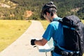 Biker with backpack consulting his route on a map