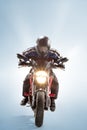 Biker in black jacket and helmet sitting on his sportive bike on blue background Royalty Free Stock Photo