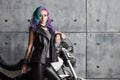 Biker chick in front of motorcycle. Beautiful and pert young woman in leather clothes Royalty Free Stock Photo