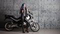 Biker chick in front of motorcycle. Beautiful and pert young woman in leather clothes Royalty Free Stock Photo