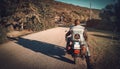 Biker on a classic motrocycle on a country road Royalty Free Stock Photo