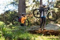 Biker couple holding their mountain bike and walking in forest Royalty Free Stock Photo