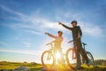 Biker couple with mountain bike pointing in distance at countryside