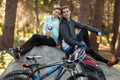 Biker couple sitting on rock in forest