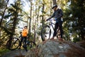 Biker couple standing with their mountain bike in forest