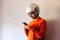 Biker dressed in orange looking at his mobile phone