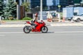 Biker on Ducati 959 Panigale sport motorbike riding on city highway. Man riding red motorcycle on city road against urban