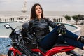 Biker girl in a leather jacket on a black and red color motorcycle Royalty Free Stock Photo