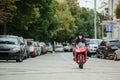 A biker girl in a leather jacket on a motorcycle rides in the city Royalty Free Stock Photo