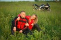 Biker girl and man sitting on the grass near a Royalty Free Stock Photo