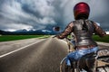 Biker girl on a motorcycle hurtling down the road in a lightning Royalty Free Stock Photo