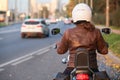 Biker girl rides a motorcycle in the city. First-person view on urban road