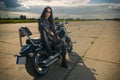 Biker girl sitting on a motorcycle.