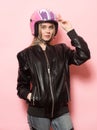 Biker girl wearing black leather jacket and pink motorcycle helmet