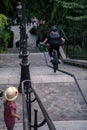 Biker going down stairs with his bike while a young girl looking at him in Montmartre, Paris, France