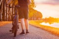 Biker with his bicycle at sunset next to a river ready to ride Royalty Free Stock Photo