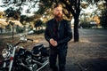 Biker in leather jacket near black chopper Royalty Free Stock Photo