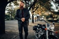 Biker in leather jacket near black chopper Royalty Free Stock Photo