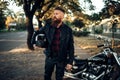 Biker in leather jacket near black chopper Royalty Free Stock Photo