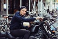 Biker man on black motorcycle parked on city street. Royalty Free Stock Photo