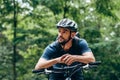 Biker man resting during riding the bike in the mountain. Male athlete in cycling gear practising outside on nature background. Royalty Free Stock Photo