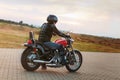 Biker man wearing a leather jacket and sunglasses sitting on his Royalty Free Stock Photo