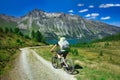Biker on mountain dirt road in beautiful landscape on the alps Royalty Free Stock Photo