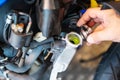 Biker removing the cap from a cold radiator and check coolant fluid levels in motorcycle at garage, motorcycle maintenance and