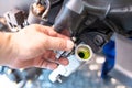 Biker removing the cap from a cold radiator and check coolant fluid levels in motorcycle at garage, motorcycle maintenance and