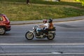 Biker ride Honda motorcycle on the city road with motion blurred background. Motorcyclist with passenger in black helmet and t-