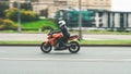 Biker ride Kawasaki motorcycle on the city road with motion blurred background. Motorcyclist in white helmet and black jacket on