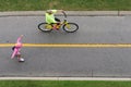 Biker rides next to skater in pink on path at Virginia Beach, VA.