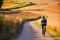 Biker riding on cycling road through summer agricultural fields which are full of gold wheat Royalty Free Stock Photo