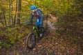 Biker riding downhill with a modern electric bicycle or mountain bike in autumn or winter setting in a forest. Modern e-cyclist in Royalty Free Stock Photo