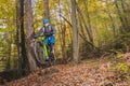 Biker riding downhill with a modern electric bicycle or mountain bike in autumn or winter setting in a forest. Modern e-cyclist in Royalty Free Stock Photo