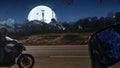 Biker riding the motorcycle at night on the road and the moon is glowing behind the mountain on the dark sky. Royalty Free Stock Photo