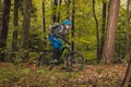 Biker riding uphill with a modern electric bicycle or mountain bike in autumn or winter setting in a forest. Modern e-cyclist in Royalty Free Stock Photo