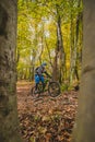 Biker riding uphill with a modern electric bicycle or mountain bike in autumn or winter setting in a forest. Modern e-cyclist in Royalty Free Stock Photo