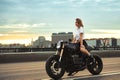 Biker sexy woman sitting on vintage custom motorcycle. Outdoor lifestyle portrait Royalty Free Stock Photo