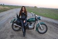 Biker sexy girl sitting on vintage custom motorcycle. Outdoor lifestyle toned portrait Royalty Free Stock Photo