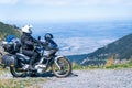 Biker is sitting on his adventure motorcycle, the top mountain in background, enduro, off road, beautiful view, danger road in Royalty Free Stock Photo