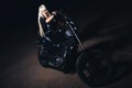 Biker woman posing on black chopper motorcycle in night time Royalty Free Stock Photo