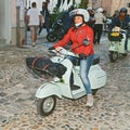 Biker woman riding a vintage italian scooter Vespa Royalty Free Stock Photo