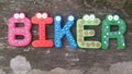 Biker word from colourful wooden stick on mossy table background