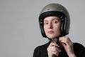 Biker young woman putting her helmet posing over white background. Mock-up. Royalty Free Stock Photo