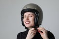 Biker young woman smiling and putting her helmet posing over white background. Royalty Free Stock Photo